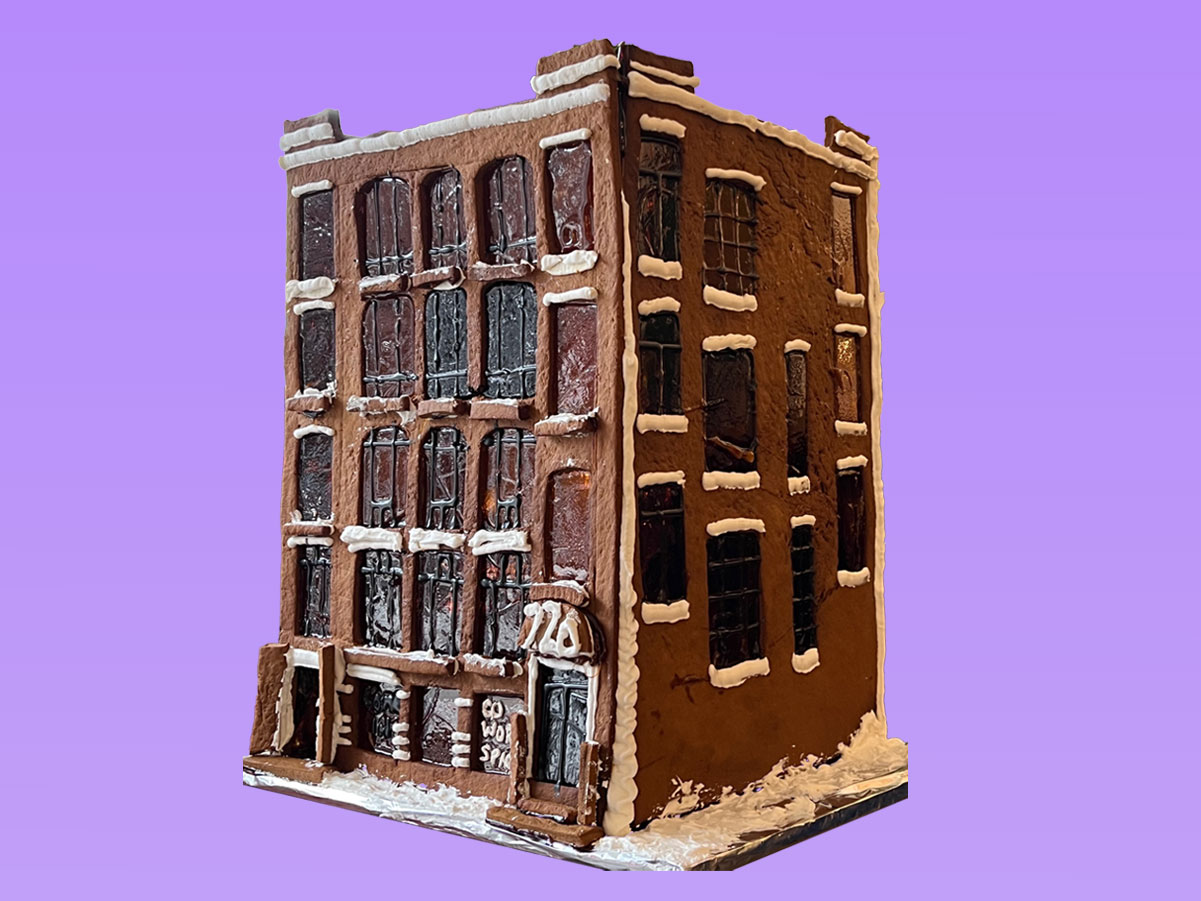 A model of building made of gingerbread featuring 5 storeys and industrial looking mullioned windows.