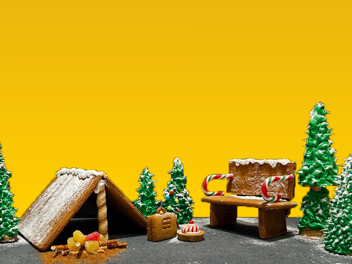 A gingerbread scene of a park including a bench, trees, and a tent.